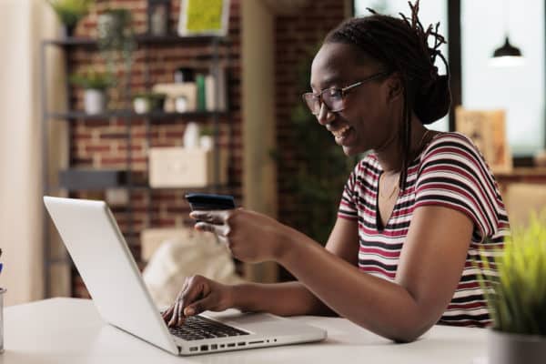 Woman holding credit card, making order in internet store Body Lift in Southlake, T